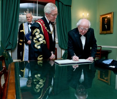 Pictured is President Michael D.Higgins (right) sigining the guest book at RCSI with RCSI President, Mr Declan Magee (left) and Professor Cathal Kelly (CEO/Registrar, RCSI) (back). On Saturday 13th February, President Higgins was presented with an Honorary Fellowship of RCSI as part of the annual Charter Day Dinner at the College on St Stephen’s Green.