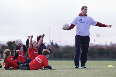 Pictured is RCSI PhD student and Meath Senior Football captain Donal Keogan with pupils from St. Enda's Primary School, Whitefriar Street and Presentation Primary School, Warrenmount, Dublin taking part in the 2015 REACH RCSI Sports Day